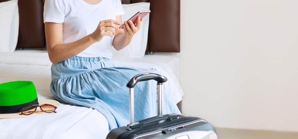 Woman sit on a bed of a hotel room